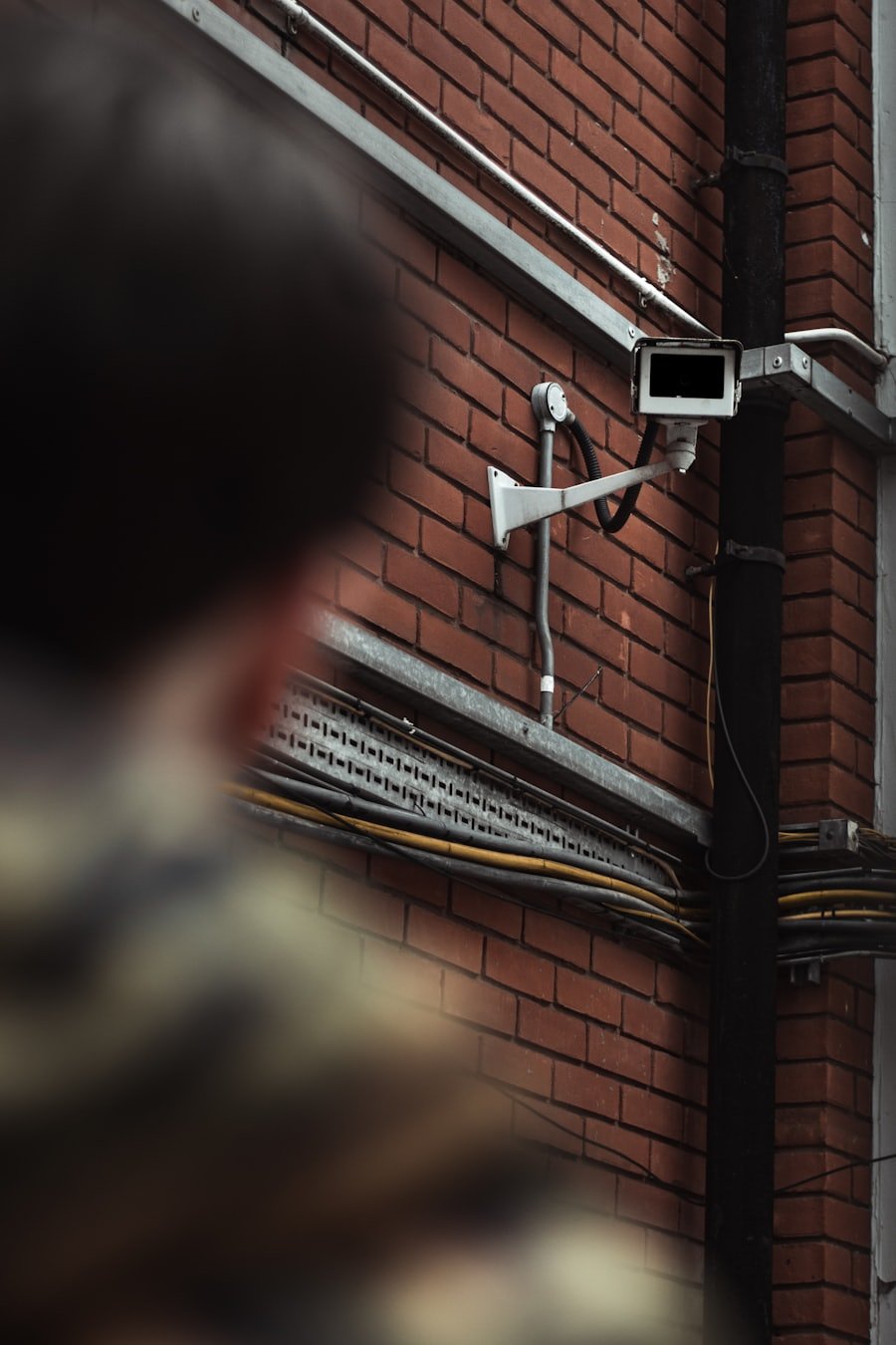 A wall-mounted CCTV camera being checked during a routine maintenance visit