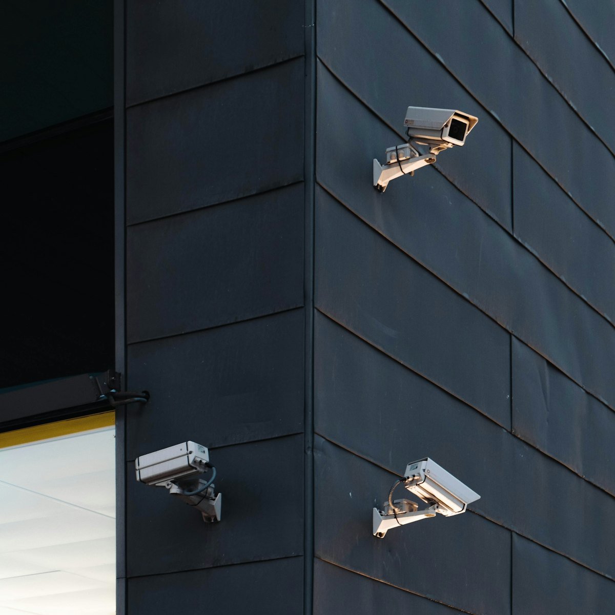 Security cameras on the corner of a multi-storey block