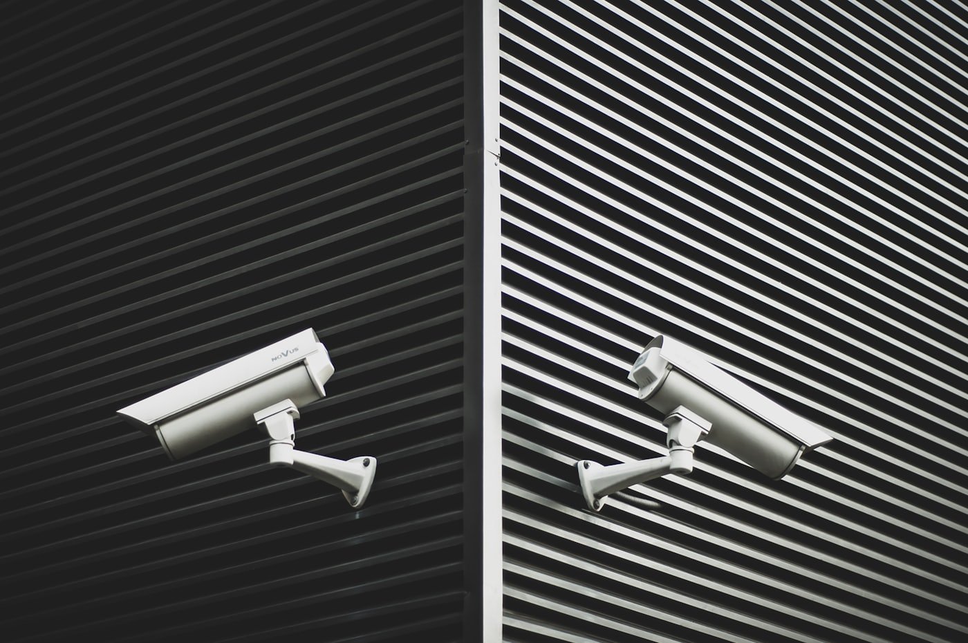 Two professionally mounted CCTV cameras on a clean building facade