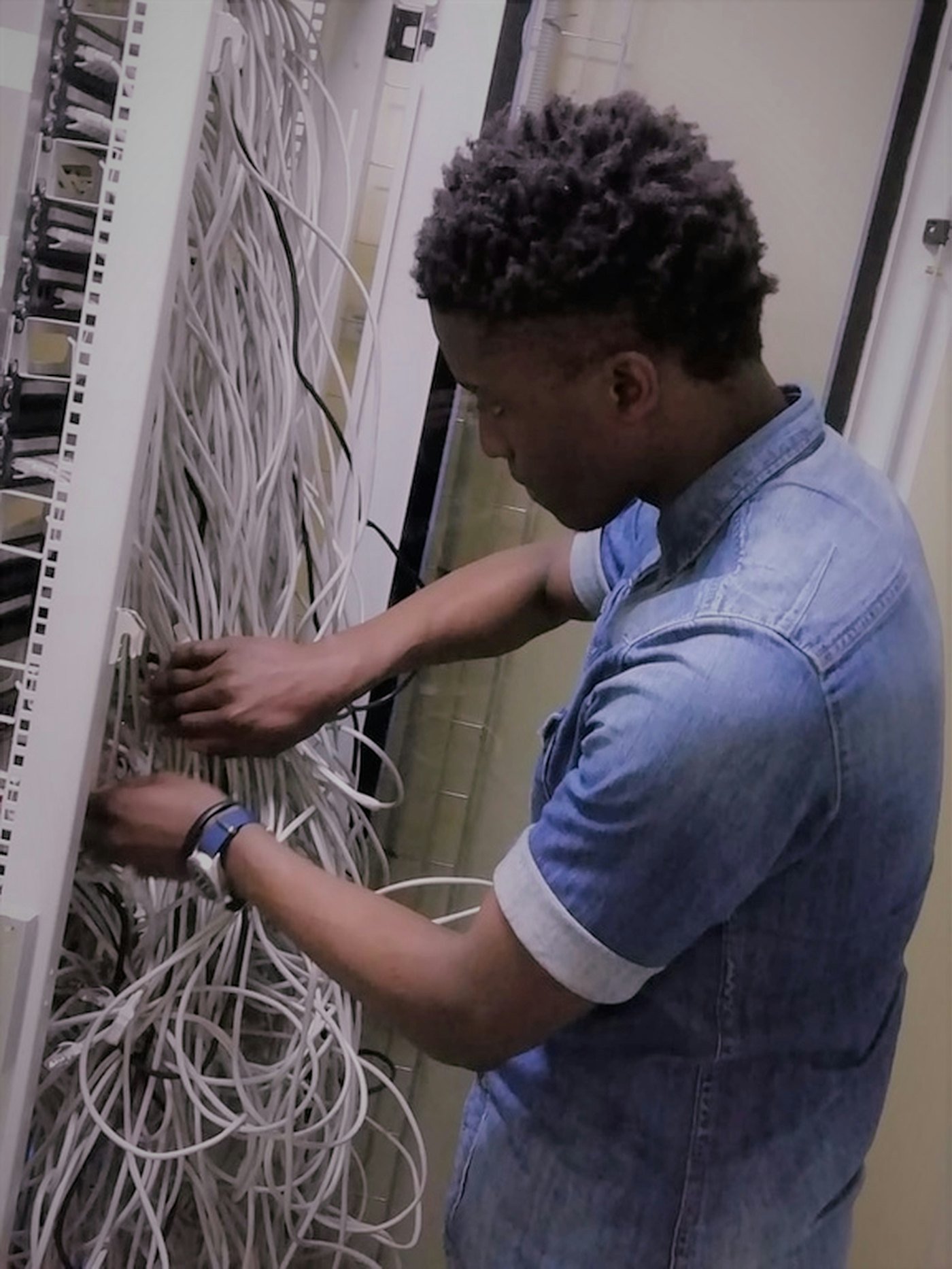 A Comobics technician terminating structured cabling at a patch panel